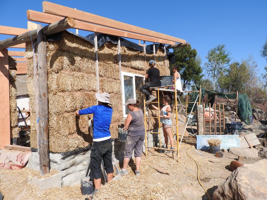 Plastering the strawbale house with clay
